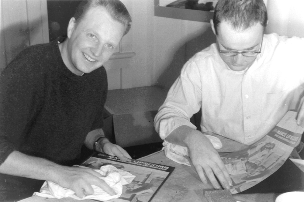 Chris Strachwitz and Wayne Pope pasting the covers of the first Arhoolie Records' release "Texas Songster," 1960. Photo by Alice Pope.